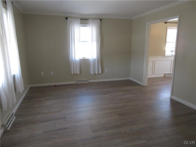 unfurnished room with crown molding, dark hardwood / wood-style floors, and a baseboard heating unit