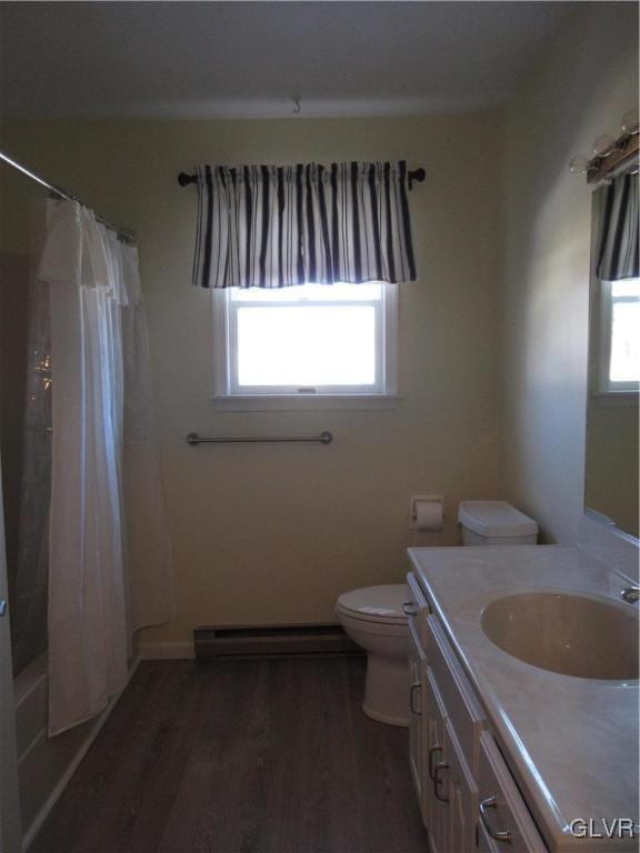 full bathroom with hardwood / wood-style floors, shower / tub combo with curtain, a baseboard radiator, vanity, and toilet