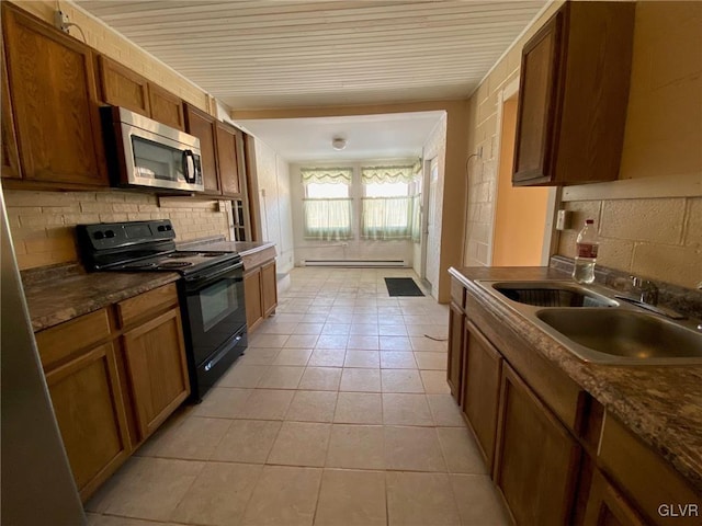 kitchen featuring sink, light tile patterned floors, backsplash, black range with electric cooktop, and a baseboard radiator