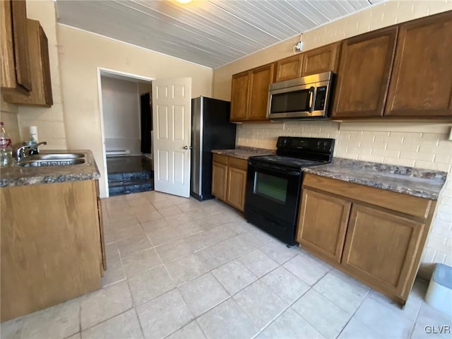 kitchen with sink, decorative backsplash, light tile patterned flooring, and appliances with stainless steel finishes