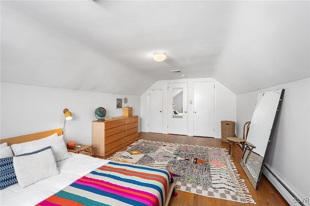 bedroom with dark hardwood / wood-style flooring, vaulted ceiling, and baseboard heating