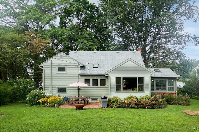 rear view of property featuring a lawn and a patio