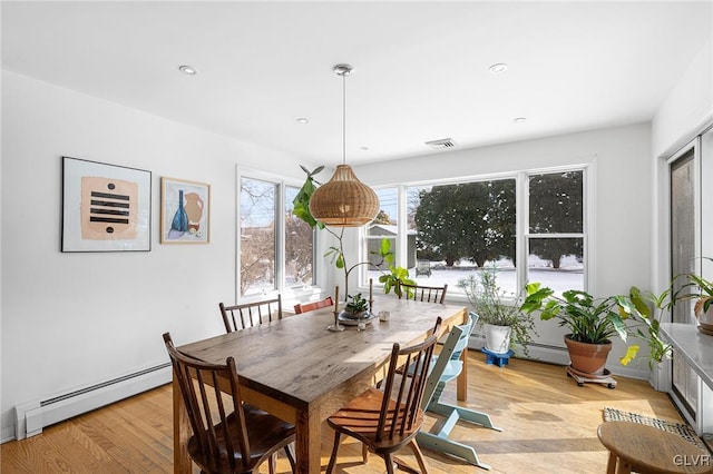 dining space featuring light hardwood / wood-style flooring and a baseboard radiator