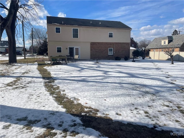 view of snow covered rear of property