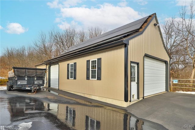 view of property exterior featuring a garage and solar panels