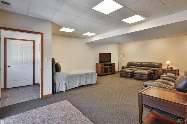 bedroom with a drop ceiling and dark carpet