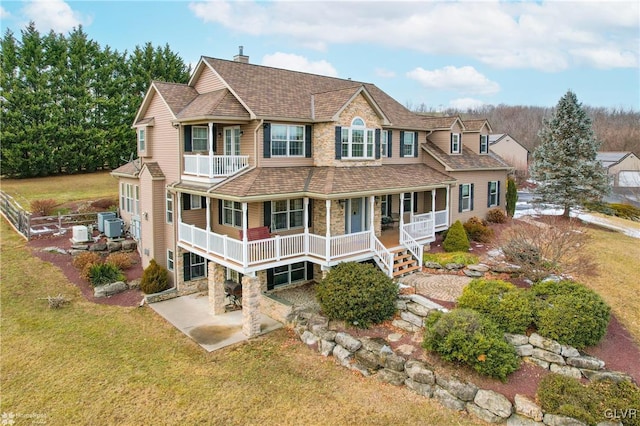 view of front of property with a porch, central air condition unit, a balcony, a front lawn, and a patio