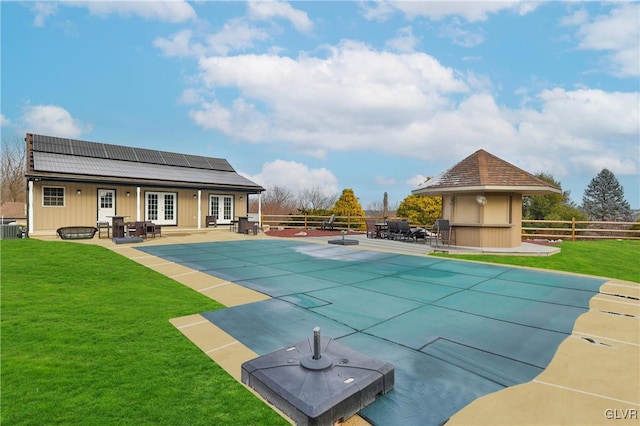 view of swimming pool with a lawn, a patio, central air condition unit, and french doors