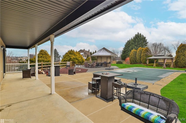 view of patio featuring a gazebo and an outdoor living space with a fire pit