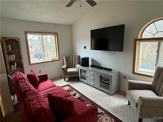 living room with ceiling fan, carpet floors, a textured ceiling, and vaulted ceiling