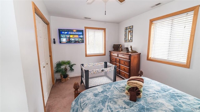 bedroom featuring light colored carpet, ceiling fan, and a closet