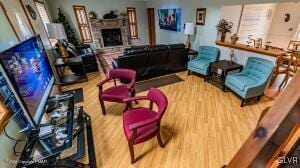 living room featuring wood-type flooring and a brick fireplace