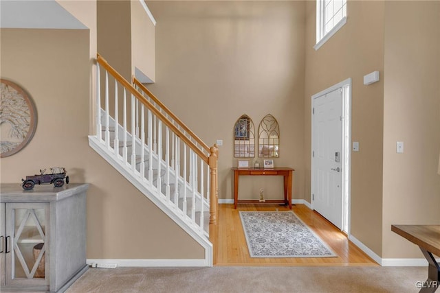 entryway with light hardwood / wood-style flooring and a high ceiling