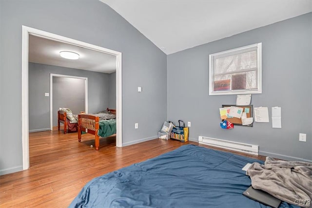 bedroom with a baseboard radiator, wood-type flooring, and vaulted ceiling