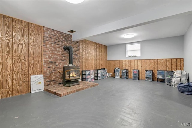 basement with wooden walls and a wood stove