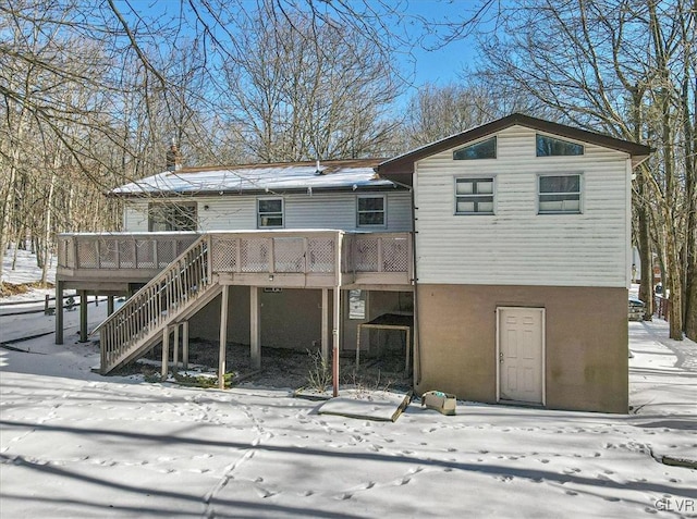 snow covered rear of property featuring a wooden deck