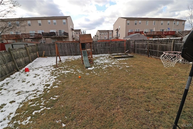 yard layered in snow with a playground