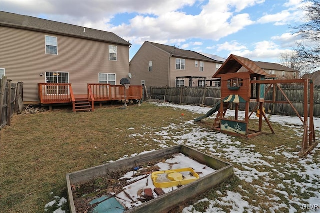 snow covered playground with a wooden deck and a lawn