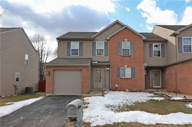 view of front of property featuring a garage and central AC unit