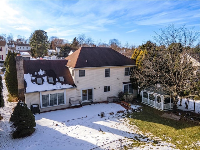 view of snow covered back of property