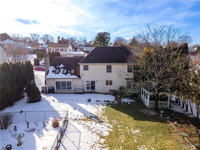 view of snow covered back of property