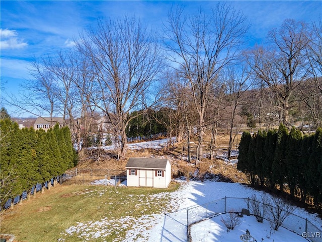 yard layered in snow featuring a storage shed