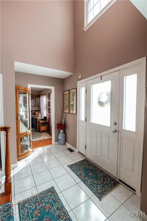 tiled foyer entrance featuring a towering ceiling