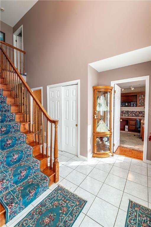 tiled foyer featuring a towering ceiling