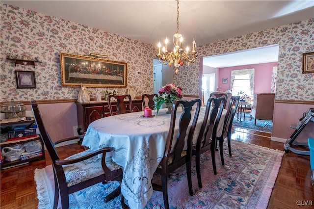 dining space featuring an inviting chandelier and dark parquet flooring