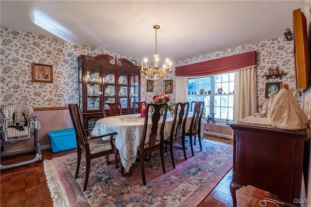 dining area with dark parquet flooring and a notable chandelier