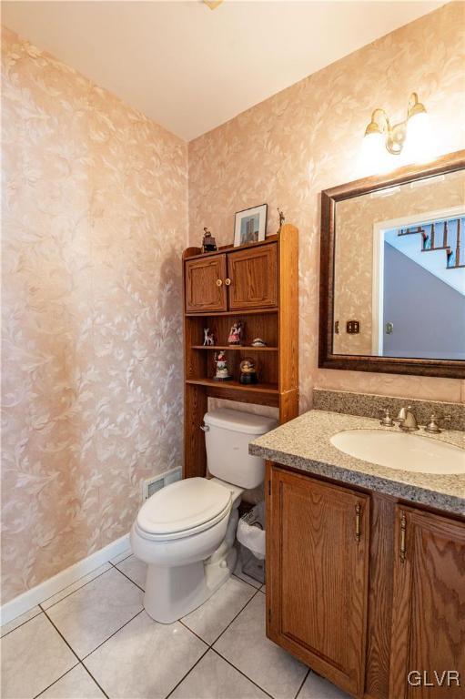 bathroom with tile patterned flooring, vanity, and toilet