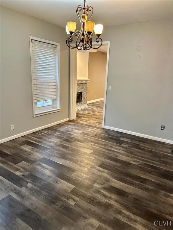 38 12th St, Allentown City, PA 18101 - unfurnished dining area with a chandelier, baseboards, dark wood finished floors, and a fireplace