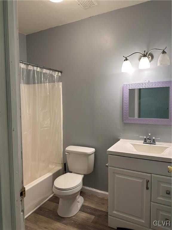 38 12th St, Allentown City, PA 18101 - full bathroom featuring wood finished floors, vanity, toilet, shower / tub combo, and baseboards