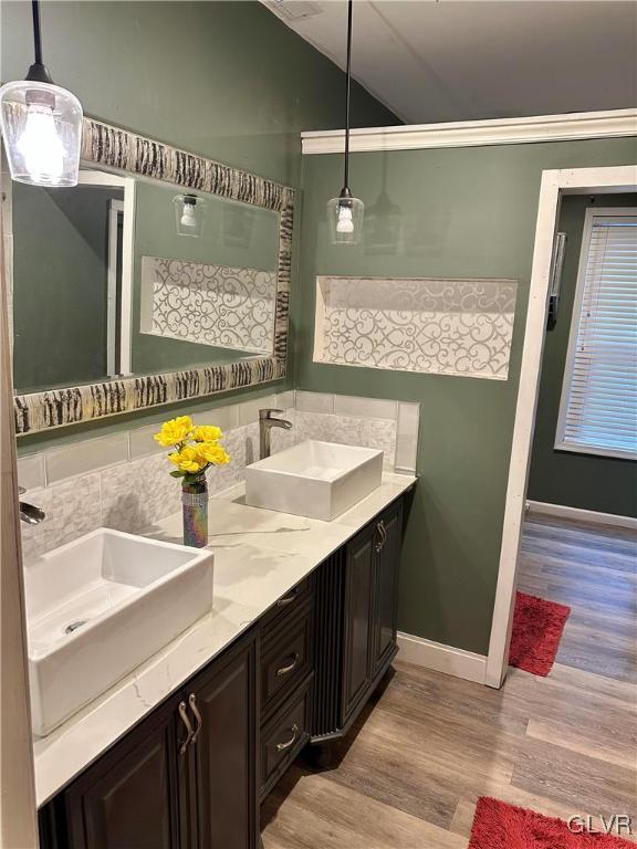 38 12th St, Allentown City, PA 18101 - bathroom with wood finished floors, lofted ceiling, double vanity, baseboards, and ornamental molding
