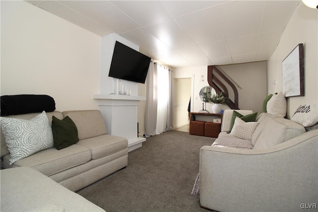 carpeted living room with a paneled ceiling