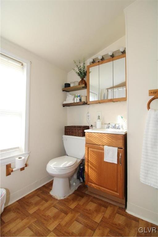 bathroom featuring vanity, parquet flooring, lofted ceiling, and toilet