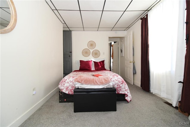 carpeted bedroom with a drop ceiling