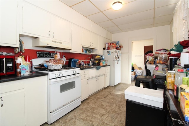 kitchen with a drop ceiling, sink, white appliances, and white cabinets