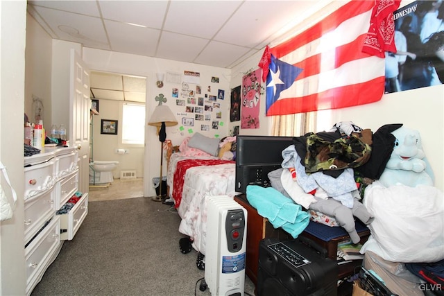 carpeted bedroom featuring connected bathroom and a paneled ceiling