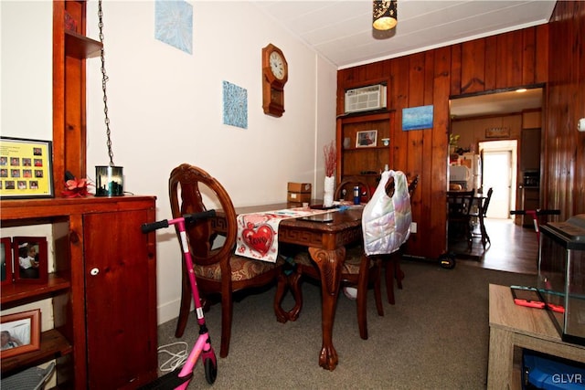 carpeted dining room with an AC wall unit and wooden walls