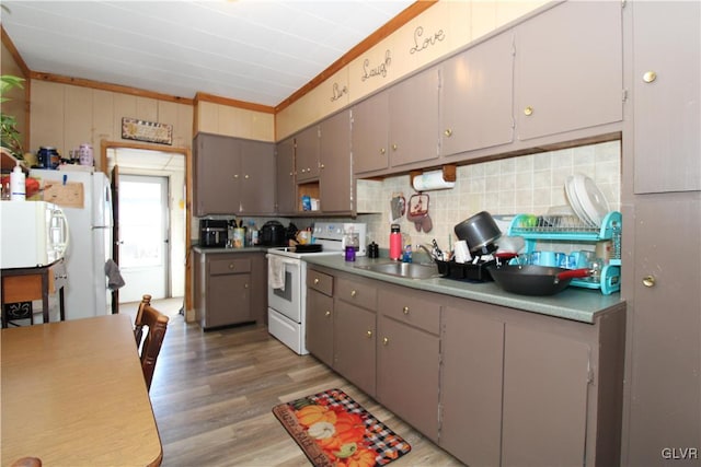 kitchen featuring sink, gray cabinetry, white appliances, light hardwood / wood-style floors, and backsplash