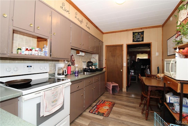 kitchen featuring ornamental molding, sink, white appliances, and light hardwood / wood-style floors