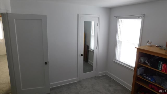 bedroom featuring multiple windows and dark carpet