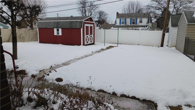 yard covered in snow featuring a storage unit