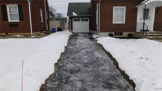 view of snowy exterior with a garage