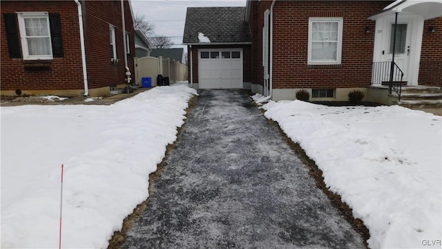 view of snowy exterior featuring a garage