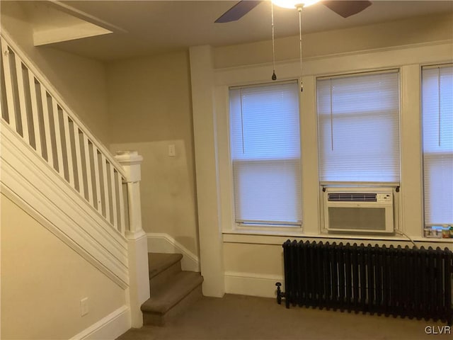 interior space featuring cooling unit, ceiling fan, radiator heating unit, and carpet