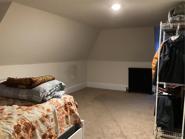 bedroom featuring lofted ceiling, radiator heating unit, and light carpet