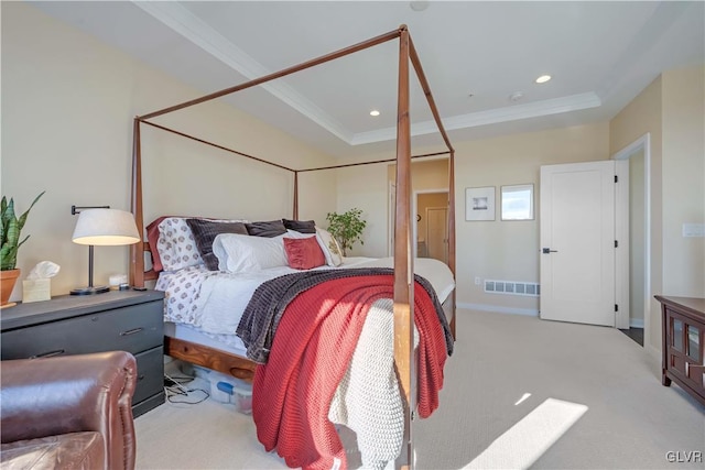 bedroom featuring ornamental molding, a tray ceiling, and light carpet