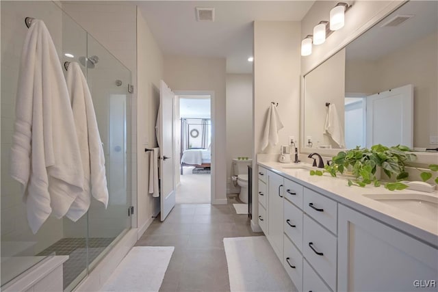 bathroom with vanity, toilet, an enclosed shower, and tile patterned flooring